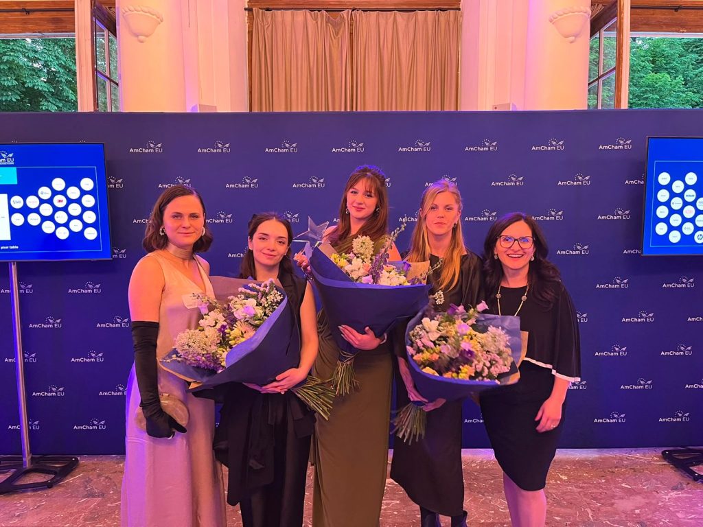 Elenya Spiteri with fellow finalists and organisers at the AmCham EU awards ceremony, each holding bouquets of flowers