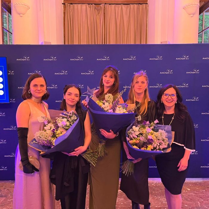 Elenya Spiteri with fellow finalists and organisers at the AmCham EU awards ceremony, each holding bouquets of flowers